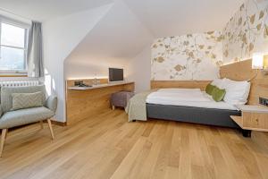 a bedroom with a bed and a chair and a desk at See- und Seminarhotel FloraAlpina Vitznau in Vitznau
