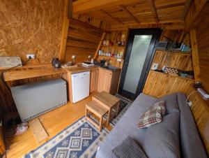 a living room with a couch and a kitchen in a cabin at A Pine vikendica u srcu Zapadne Srbije in Nova Varoš