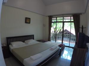 1 dormitorio con cama y ventana grande en The Old Palace Resort Klong Sa Bua, en Phra Nakhon Si Ayutthaya