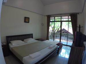 a bedroom with a bed and a large window at The Old Palace Resort Klong Sa Bua in Phra Nakhon Si Ayutthaya