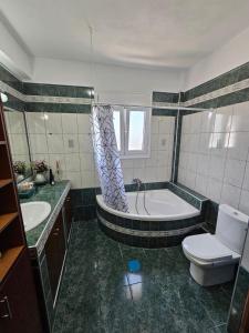 a bathroom with a tub and a toilet and a sink at Sweet Dreams Villa in Pondolívadhon +125 photos