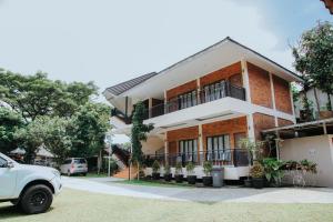 a white car parked in front of a building at Saung Dolken Syariah Resort & Hotel in Sukaraja