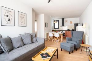a living room with a couch and chairs and a kitchen at Puerto Canalejas 1 in Santander
