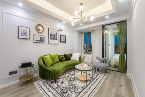 a living room with a green couch and a table at 云深处江景公寓 in Chongqing