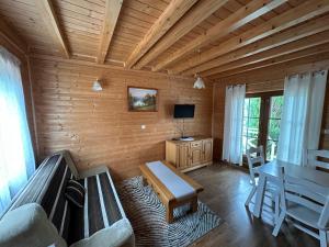 a living room with a couch and a table at Domki u Polaka in Uherce Mineralne (7)