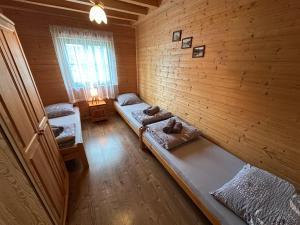 a room with two beds in a wooden wall at Domki u Polaka in Uherce Mineralne (7)