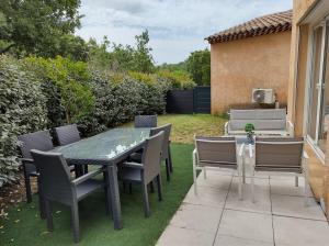 TourvesXcoquine Love Room & Spa的露台上的草地上摆着桌椅