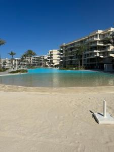 ein weißes Objekt am Strand vor einem Gebäude in der Unterkunft Marassi 2-bed Marina Views Sandy Lagoon in El-Alamein