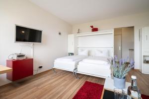 a bedroom with a white bed and a red rug at Stranddistel 4 Hafenkoje in Burgtiefe auf Fehmarn 