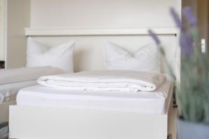 a white bed with white sheets and pillows at Stranddistel 4 Hafenkoje in Burgtiefe auf Fehmarn  +12 photos