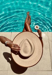 a woman laying in the swimming pool with a hat at Nomas Living in Kalamaki +39 photos