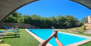 a person with their feet in the air next to a swimming pool at Duplex Love Room & Spa in Tourves +27 photos