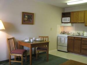 a kitchen with a table and chairs and a kitchen with a stove at Affordable Suites Conover / Hickory in Conover