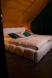 a large white bed with two pillows on it at Hygge Sauna&Spa in Gleźnowo