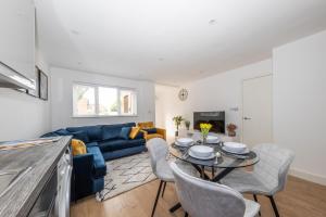 a living room with a blue couch and a table at Spacious 2 bedroom home, Contractors friendly and free parking in Luton