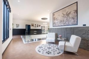 ein Wohnzimmer mit 2 weißen Stühlen und einem Glastisch in der Unterkunft Sun Sky Villa 6 Bed Pool BBQ KTV Group Friendly - 7 in Pattaya South