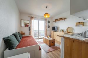un soggiorno con divano e cucina di Appartement au pied des dunes avec vue a Biscarrosse