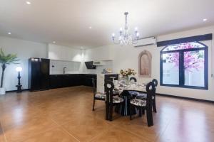 ein Esszimmer mit Tisch und Stühlen in der Unterkunft Sun Sky Villa 6 Bed Pool BBQ KTV Group Friendly - 7 in Pattaya South