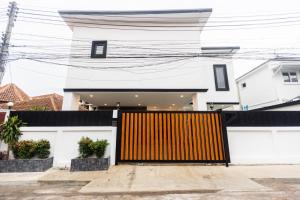 ein Haus mit einem gelben Tor davor in der Unterkunft Sun Sky Villa 6 Bed Pool BBQ KTV Group Friendly - 7 in Pattaya South