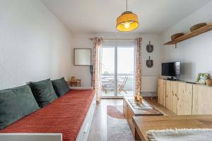 un soggiorno con un divano e una TV di Appartement au pied des dunes avec vue a Biscarrosse