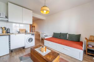 un soggiorno con divano e cucina di Appartement au pied des dunes avec vue a Biscarrosse