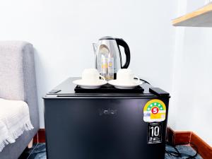 a coffee maker sitting on top of a black refrigerator at ฐิติพร อพาร์ทเมนต์ บางเขน in Tha Akatsayan Don Muang