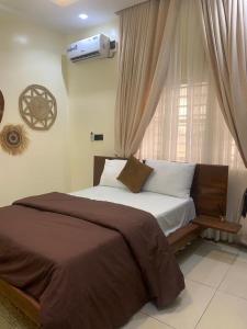 a bedroom with a large bed with a window at pearlsendapartments in Lagos