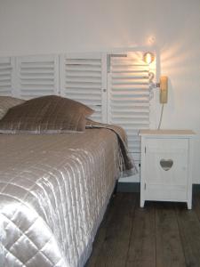 a bedroom with a bed and a table with a lamp at Le Parasol in Ars-en-Ré