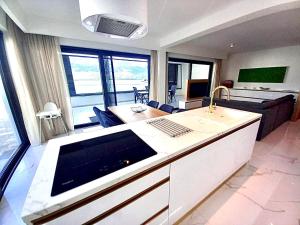 a kitchen and living room with a couch and a table at Luxury beachfront apartment with private pool, Vinjerac in Vinjerac