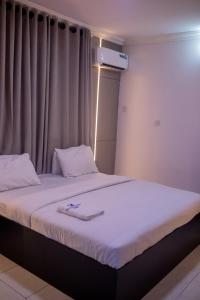A bed or beds in a room at Skyrock Hotels Ogba