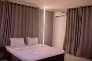 A bed or beds in a room at Skyrock Hotels Ogba