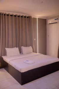 A bed or beds in a room at Skyrock Hotels Ogba