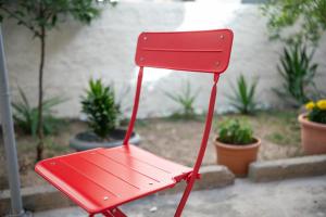a red chair sitting in front of some plants at Skyard - Central 2bd House in Kos