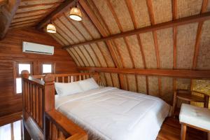 un lit dans une chambre avec un plafond en bois dans l'établissement Luh Adi Villa 1, Balinese Wooden House in Uluwatu, à Uluwatu