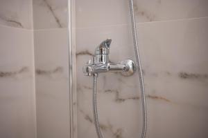 a shower with a silver shower head in a bathroom at Skyard - Central 2bd House in Kos +41 photos