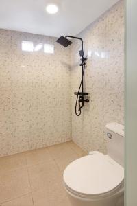 une salle de bain avec toilettes et une lumière au mur dans l'établissement Luh Adi Villa 1, Balinese Wooden House in Uluwatu, à Uluwatu 7 autres photos