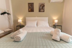 a bedroom with a large white bed with towels on it at Skyard - Central 2bd House in Kos