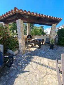 a patio with a picnic table and a fireplace at Apartment Oliva Volme in Banjole