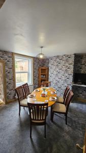 a dining room with a wooden table and chairs at Entire Charming Three Bedroom Seaside House With Garden - Close to Town & Beach, Ideal for Groups, Families in Sheringham