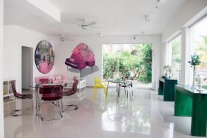 un comedor con mesas y sillas rosas y amarillas en Art Villa Dominicana, en Punta Cana