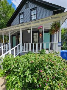ein graues Haus mit einer weißen Veranda mit rosa Blumen in der Unterkunft Vintage Eastside Beltline Trail Apartment by Krog St Market with Free Parking in Atlanta