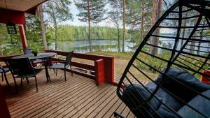 a porch with a table and chairs and a view of a lake at Nature Dream Days in Muhos