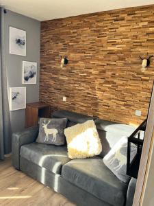 a living room with a couch and a brick wall at Val Thorens Appartement Cosy centre station in Val Thorens