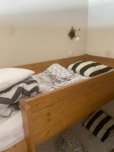 a wooden bed with two pillows on top of it at Val Thorens Appartement Cosy centre station in Val Thorens