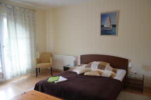 a bedroom with a bed and a chair at Villa Ladver in Hévíz