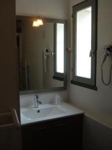 a bathroom with a sink and a large mirror at Le Parasol in Ars-en-Ré