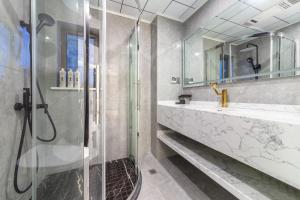 a bathroom with a glass shower and a sink at 云深处江景公寓 in Chongqing