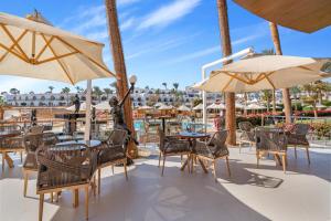 a patio with tables and chairs and umbrellas at Royal Savoy Sharm El Sheikh in Sharm El Sheikh