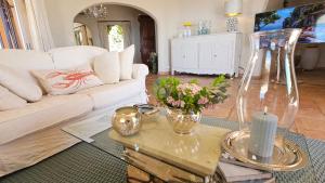 salon z białą kanapą i stołem z kwiatami w obiekcie Charmante Luxusvilla vue de rêve, aussergewöhnlich großer Pool, Meerblick w mieście Théoule-sur-Mer