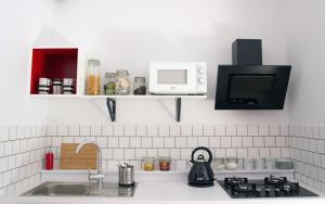 a kitchen counter with a sink and a microwave at SPOKO Hostel in Gdańsk